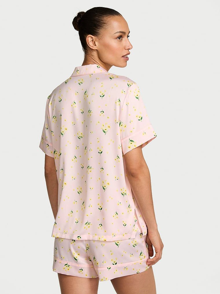 Pijamale de satin cu pantaloni scurți semnătură. Produsul are un model floral și provine din colecția Victoria's Secret.