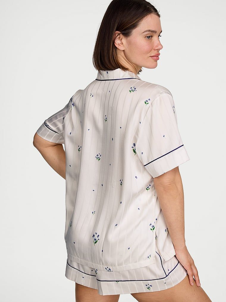 Pijamale de satin cu pantaloni scurți semnătură. Produsul are un model floral și provine din colecția Victoria's Secret.