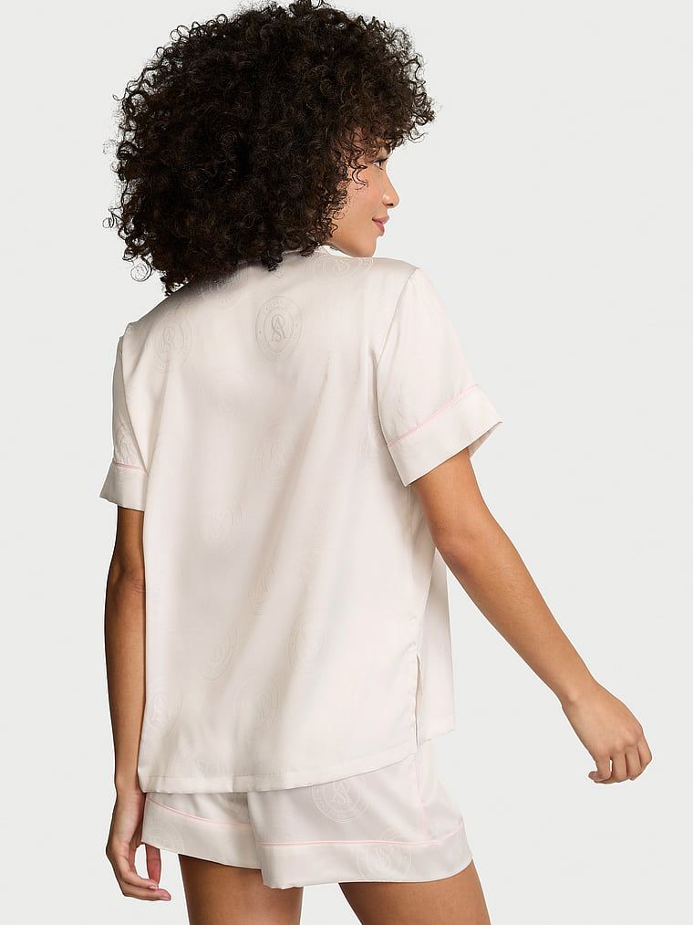 Pijamale de satin cu pantaloni scurți semnătură. Produsul este alb și provine din colecția Victoria's Secret.